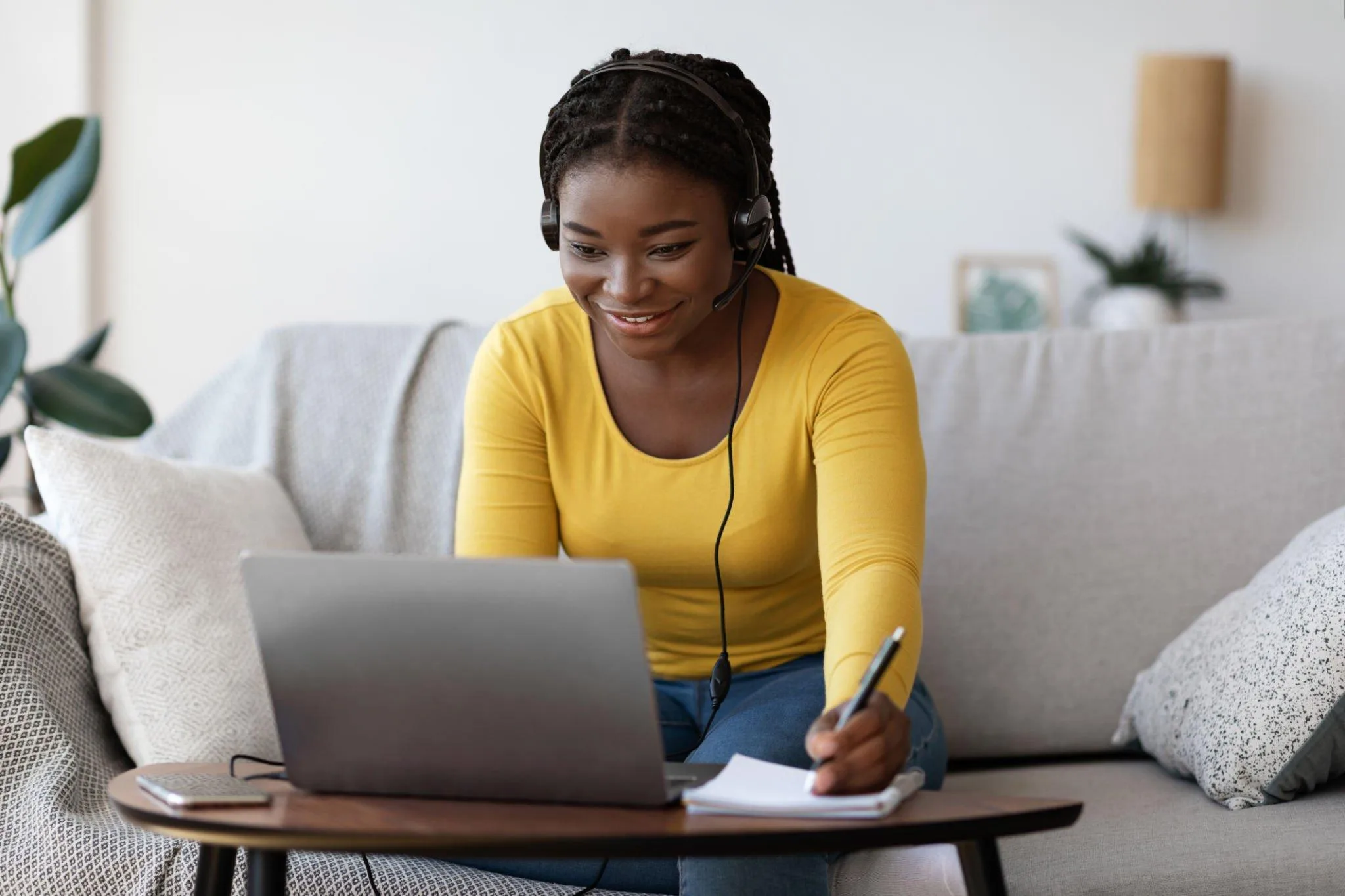 Smiling student with a headset studying on her laptop